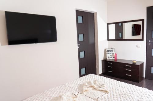 a bedroom with a bed with a tv and a dresser at Casa M&R in Bucharest