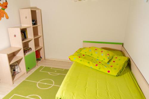a small bedroom with a green bed with polka dots at Casa M&R in Bucharest