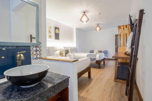 a bathroom with a sink and a bedroom with a bed at Hetai Boutique Hotel in Chiang Mai