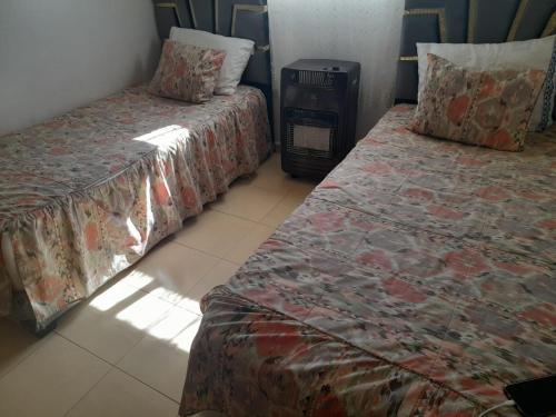 dwa łóżka ustawione obok siebie w pokoju w obiekcie Appartement azrou w mieście Azrou