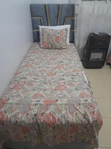 łóżko w pokoju z narzutą w obiekcie Appartement azrou w mieście Azrou