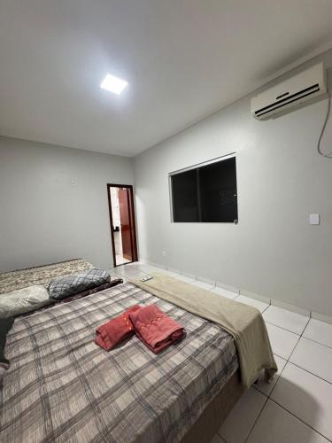 - une chambre avec un lit et 2 serviettes rouges dans l'établissement Casa Recanto da Paz Premium 2025, à Gurupi