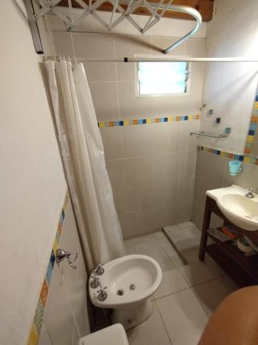 a bathroom with a toilet and a sink at Cabañas Megustayacanto in Villa Yacanto