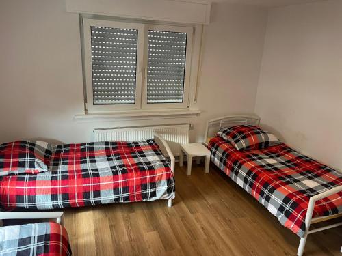 two beds and a couch in a room with a window at Heusenstamm Home & Work in Heusenstamm