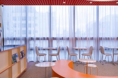 a group of tables and chairs in a room with windows at THE EXTAY Lounge Jongno in Seoul