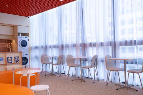 a group of tables and chairs in a room with windows at THE EXTAY Lounge Jongno in Seoul