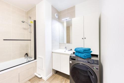 a washing machine in a bathroom with a sink at Escapade urbaine CDG Paris a deux pas in Le Blanc-Mesnil