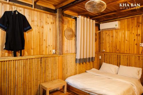 a room with a bed in a wooden wall at Kha Bản Homestay in Cao Bằng