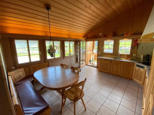 eine Küche mit Tisch und Stühlen in einem Zimmer in der Unterkunft Ferienhaus Schönenmatte in Zweisimmen