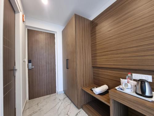 a bathroom with a wooden wall with a coffee maker at Nomad Luxe Vista in Dalhousie