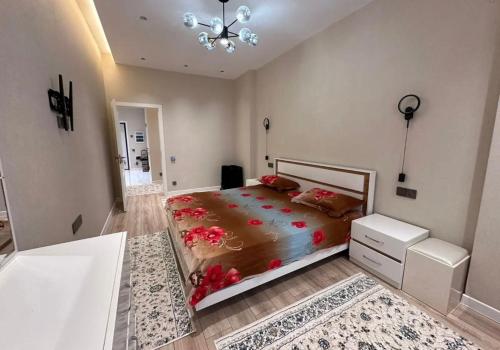 ドゥシャンベにあるComfort Homeのベッドルーム1室(赤い花の大きなベッド1台付)