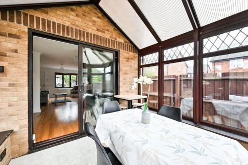 a dining room with a white table and chairs at Quiet & Modern Contemporary Home for Work & Family in Bedford
