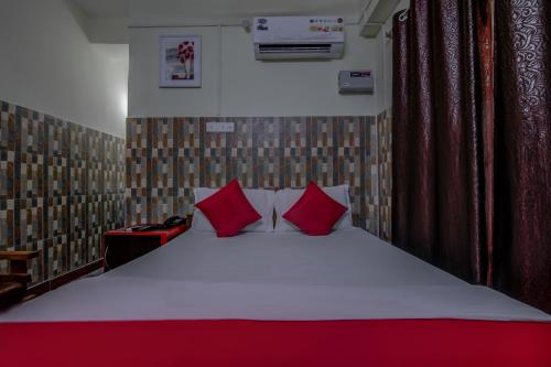 a bedroom with a large bed with red pillows at Hotel O V Knot Residency in Port Blair