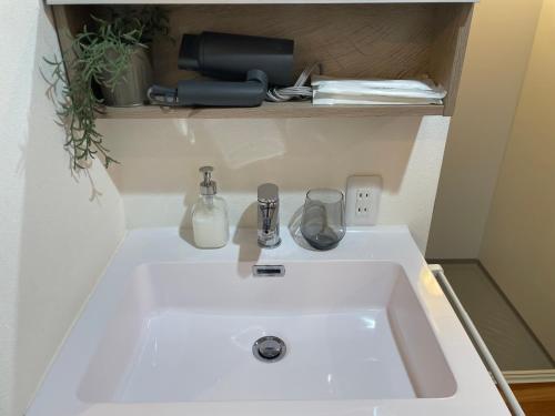 a white sink in a small room with at Le Cave Troll ル カーブ トロル in Mitaka