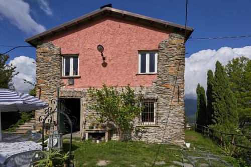 a house with a stone chimney on the side of it at @gatetothewild in Coreglia Ligure