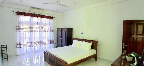 a bedroom with a bed and a window at Ambalangoda Villa in Ambalangoda