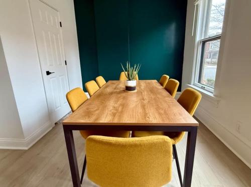 a dining room with a wooden table and yellow chairs at Short North Convention King Bed Free Parking! in Columbus