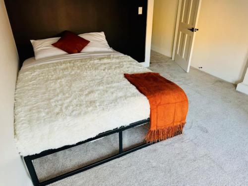 a bedroom with a bed with an orange blanket on it at Short North Convention King Bed Free Parking! in Columbus