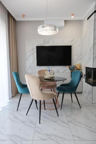 a dining room with a table and chairs and a tv at Apartment LUXOR - Airport Katowice-Pyrzowice in Bobrowniki