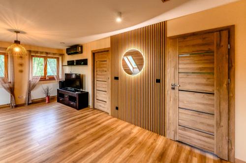 a living room with a wooden door and a television at Rodzinne wczasy nad Czarną Hańczą 