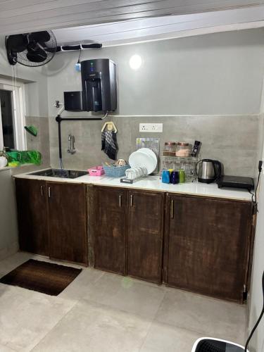 une cuisine avec des armoires en bois et un évier dans l'établissement Salted Shores 2BHK Beach Heritage Home, à Anjuna