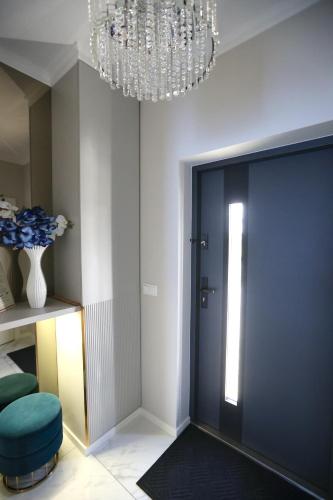 a room with a door and a chandelier at Apartment LUXOR - Airport Katowice-Pyrzowice in Bobrowniki