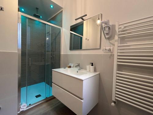 a bathroom with a sink and a glass shower at 4 Star Bologna Train Station - Self Check-In in Bologna