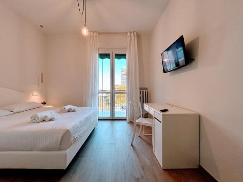 a bedroom with a bed and a desk with a television at 4 Star Bologna Train Station - Self Check-In in Bologna