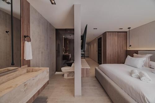 a bedroom with a large bed and a bathroom at Modern & Elegant Loft in El Poblado in Medellín