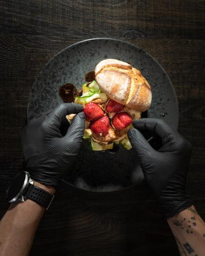 a person is holding a sandwich with fruit on it at nif: alpine taste in Levico Terme
