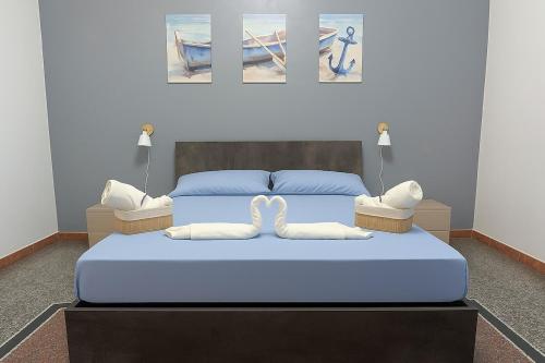 - une chambre avec un lit bleu et 2 oreillers blancs dans l'établissement La Casa Al Mare, à Vado Ligure