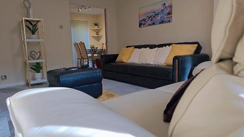 a living room with a couch and a chair at Modern luxury 3-bedroom guesthouse in Wigan in Wigan