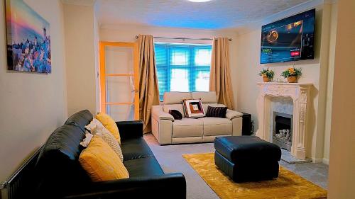 ein Wohnzimmer mit Couch und Kamin in der Unterkunft Modern luxury 3-bedroom guesthouse in Wigan in Wigan