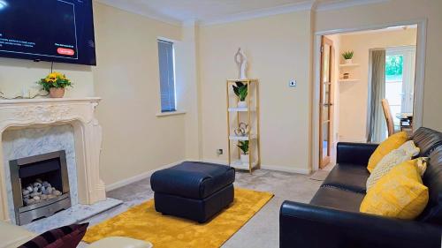 a living room with a couch and a fireplace at Modern luxury 3-bedroom guesthouse in Wigan in Wigan