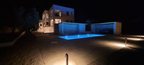 a swimming pool at night in front of a house at TAO House in Ferma