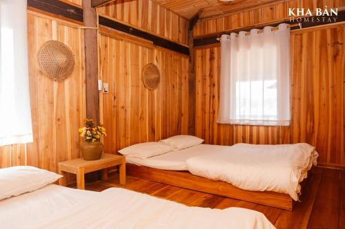 two beds in a room with wooden walls at Kha Bản Homestay in Cao Bằng