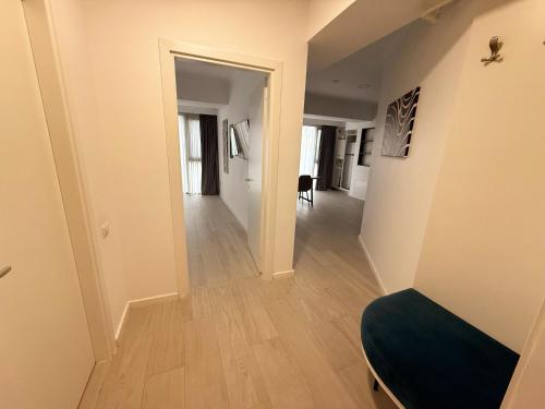 a hallway leading to a living room with wood floors at Maritimo ApartHotel in Constanţa