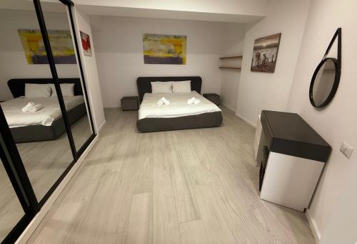 a small room with two beds and a mirror at Maritimo ApartHotel in Constanţa