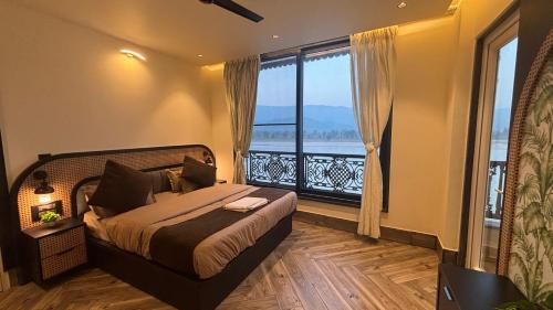 a bedroom with a bed and a large window at Evara By The Ganges in Rishīkesh