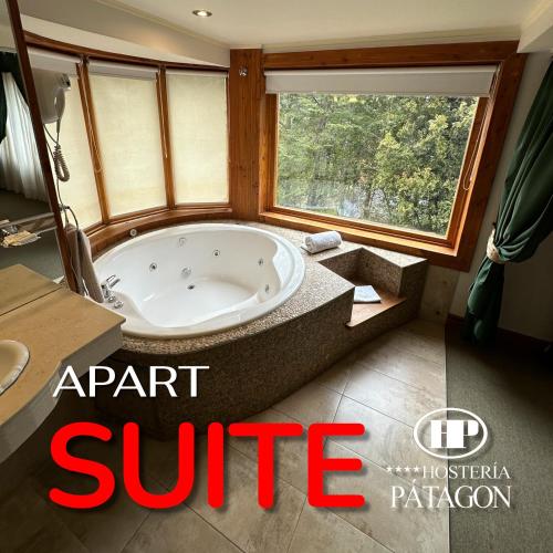 a bathroom with a jacuzzi tub and a window at Hosteria Patagon in Villa La Angostura