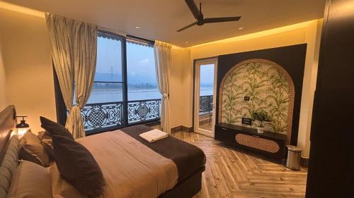 a bedroom with a large bed and a large window at Evara By The Ganges in Rishīkesh