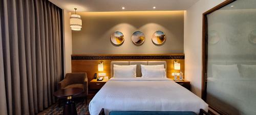 a hotel room with a bed and two mirrors at Charmwood Hotel in Leh