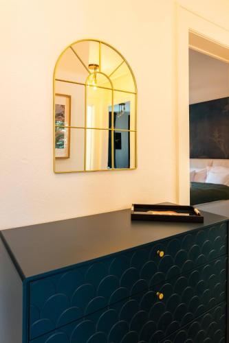 a bedroom with a large mirror and a bench at Velvet Flat · Unterstrass in Zurich