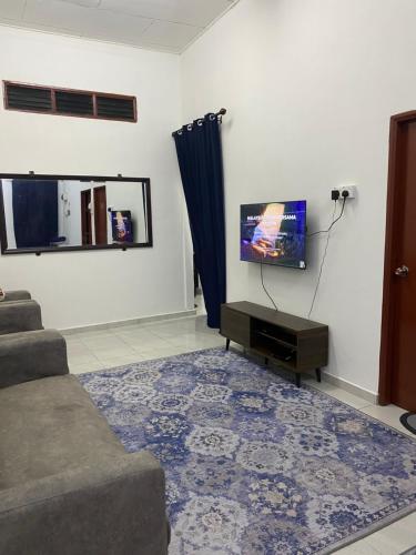 a living room with a couch and a flat screen tv at Obah Homestay Kota Bharu in Kota Bharu