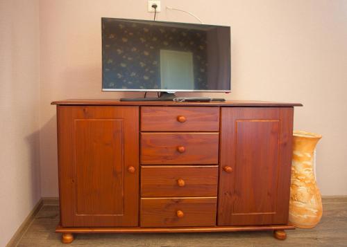 a wooden dresser with a tv on top of it at Fazenda in Sumy