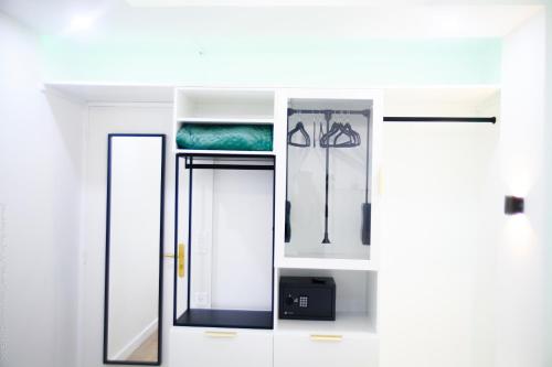 a bathroom with white cabinets and a mirror at Le Cocoon des Lierres - Séjour Zen près du Parc Astérix & CDG in Survilliers