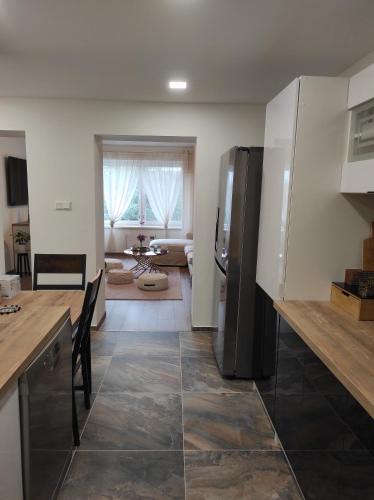 a kitchen with a stainless steel refrigerator and a table at Nina apartman in Komárno