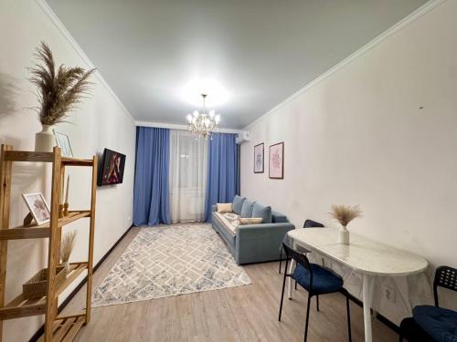 a living room with a couch and a table at Апартаменты в ЖК Ирина рядом с Баянтау in Pavlodar