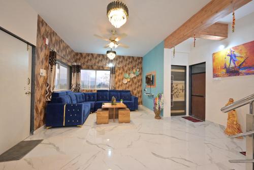 a living room with a blue couch and a table at ll EMPYREAN STAY ll LEONCINO VILLA II 4BHK ll AC ll LARGEST POOL ll in Lonavala