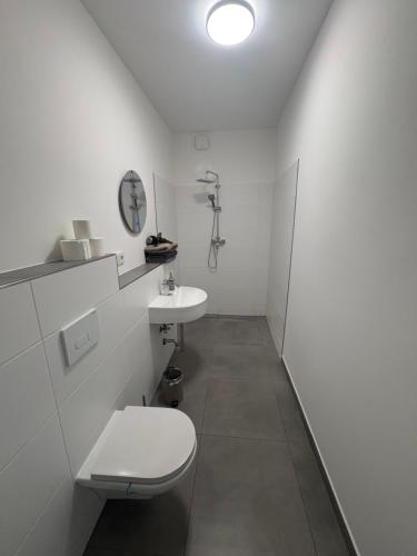 ein weißes Badezimmer mit Toilette und Waschbecken in der Unterkunft Appartement de luxe in Löhne
